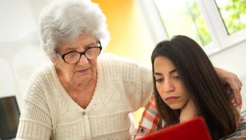 Grandmother and granddaughter looking at a laptop